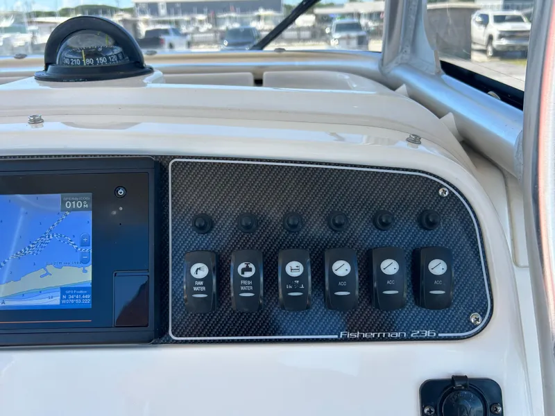 Slide: The Image of 2019 Grady-White Fisherman 236 dashboard with navigation screen and control switches. - 16