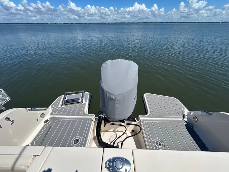 Slide: The Image of 2019 Grady-White Fisherman 236 boat on calm water, featuring covered outboard motor. - 2