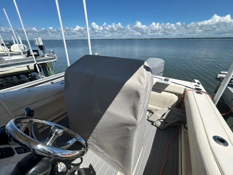 Slide: The Image of 2019 Grady-White Fisherman 236 boat interior with steering wheel, docked by calm waters. - 7