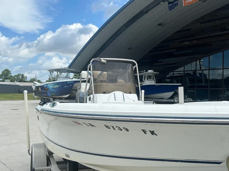 Slide: The Image of 2004 Polar 184 boat on trailer, parked outside a modern building under a cloudy sky. - 6