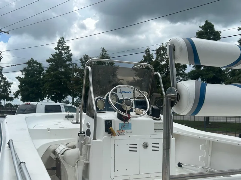 Slide: The Image of 2004 Polar 184 boat with steering console, under cloudy sky, parked near trees and vehicles. - 7