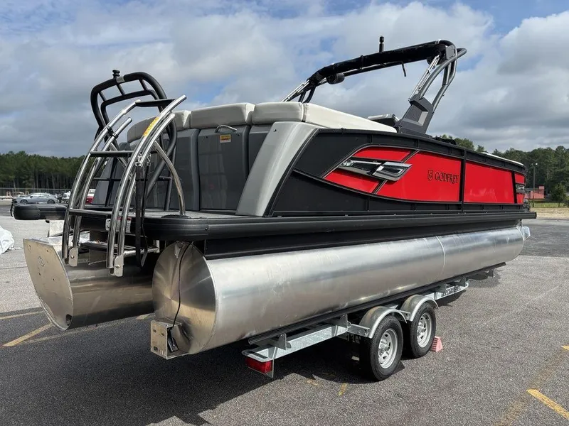 Slide: The Image of 2026 Godfrey AquaPatio 255 ULC pontoon boat on trailer, featuring sleek red and black design. - 5