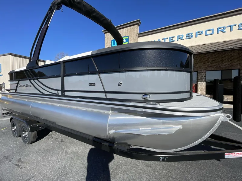 Slide: The Image of 2025 South Bay S224RS pontoon boat on trailer outside dealership. - 10