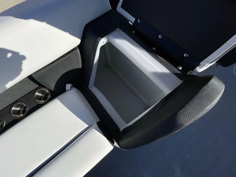 Slide: The Image of 2025 South Bay S224RS boat seat storage compartment with cup holders, open lid. - 15