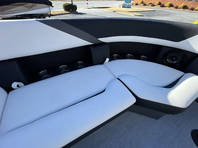 Slide: The Image of 2025 South Bay S224RS boat interior with sleek white and black seating and cup holders. - 18