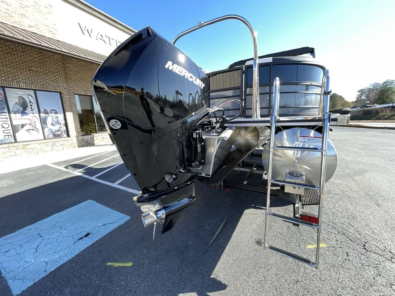 Slide: The Image of 2025 South Bay S224RS pontoon boat with Mercury outboard motor in a parking lot. - 5