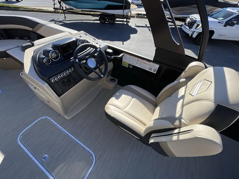 Slide: The Image of 2025 South Bay S224RS boat interior with steering console and beige seating. - 18