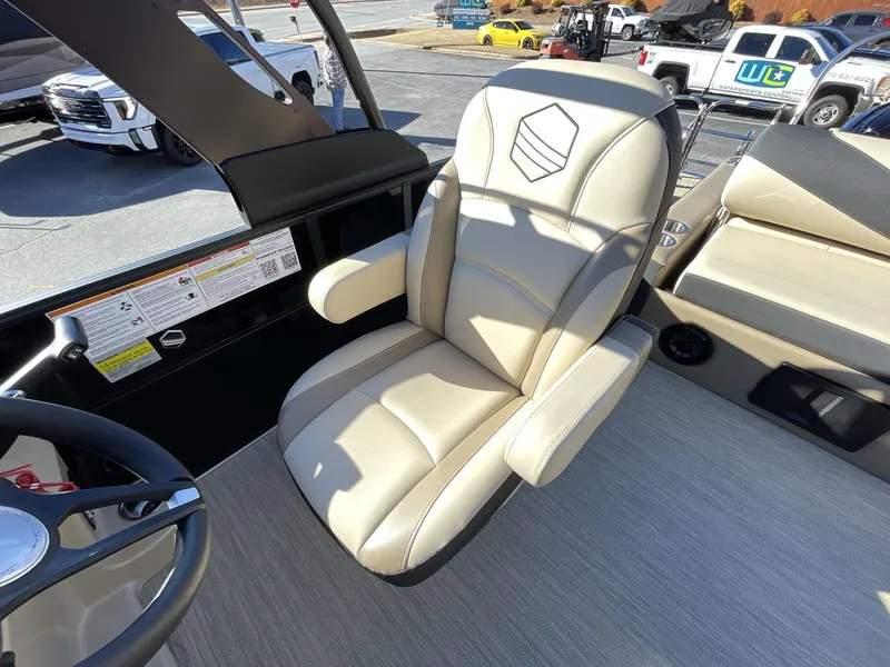 Slide: The Image of Captain's chair on 2025 South Bay S224RS pontoon boat, featuring beige upholstery and armrests. - 21