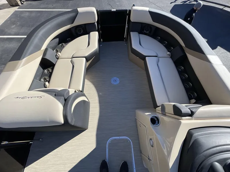 Slide: The Image of 2025 South Bay S224RS pontoon boat interior with beige seating and cup holders. - 24