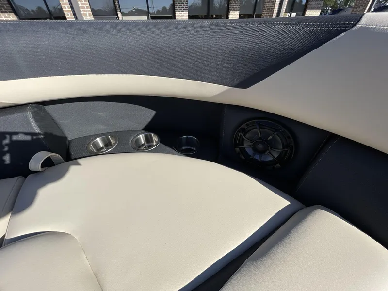 Slide: The Image of 2025 South Bay S224RS boat interior with cup holders and speaker, featuring sleek upholstery design. - 27