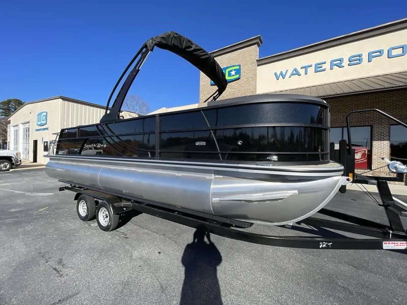 Slide: The Image of 2025 South Bay S224RS pontoon boat on trailer outside dealership. - 7