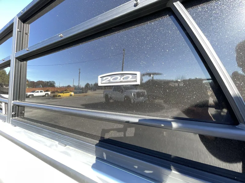 Slide: The Image of 2025 South Bay S224RS boat window with "200" emblem, reflecting outdoor scene. - 8