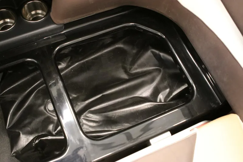 Slide: The Image of 2018 Supra SR400 interior storage compartment with black lining and cup holders. - 100