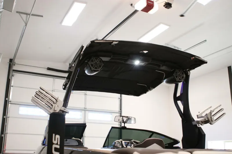 Slide: The Image of 2018 Supra SR400 boat in garage, featuring wakeboard tower and speakers. - 109
