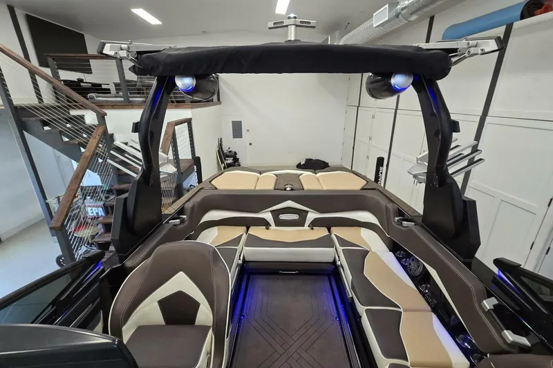 Slide: The Image of 2018 Supra SR400 boat interior with modern seating and sleek design in a garage setting. - 3