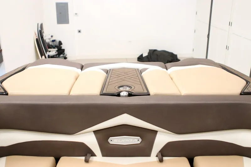 Slide: The Image of 2018 Supra SR400 boat interior with beige and brown seating in a garage setting. - 57