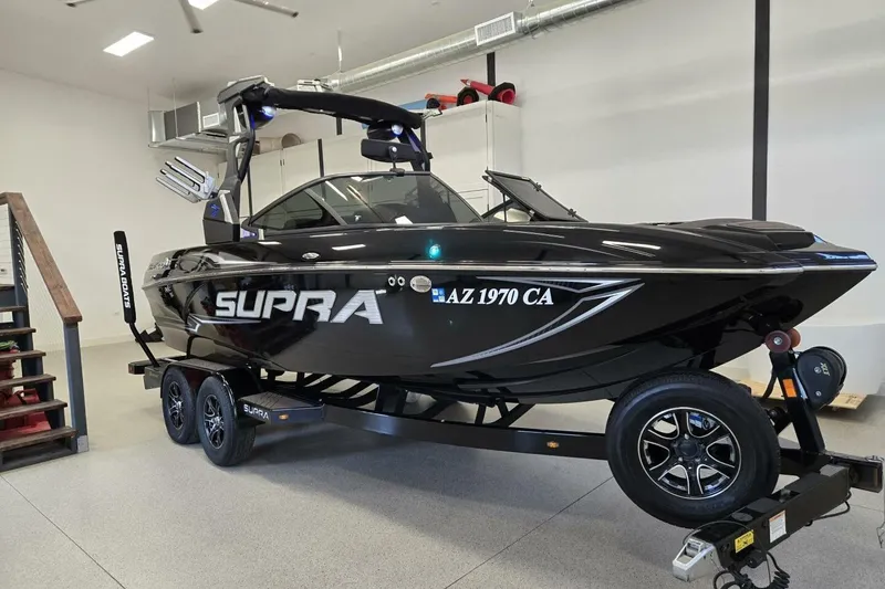 The Image of 2018 Supra SR400 boat on trailer in garage, sleek black design, modern features. - 0