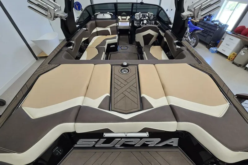 Slide: The Image of 2018 Supra SR400 boat interior with beige and brown seating, modern dashboard, and spacious layout. - 1