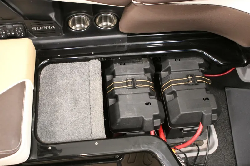 Slide: The Image of Interior of a 2018 Supra SR400 showing battery compartment and cup holders. - 62