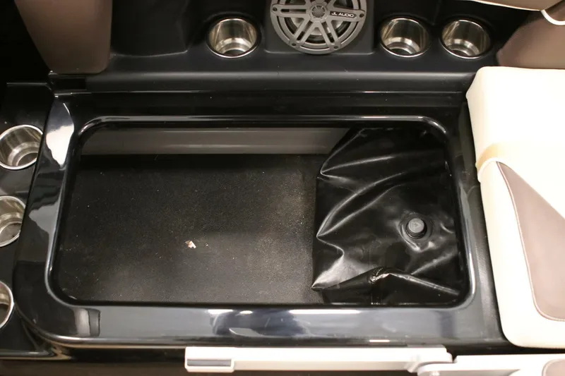 Slide: The Image of 2018 Supra SR400 boat storage compartment with cup holders and audio speaker. - 99