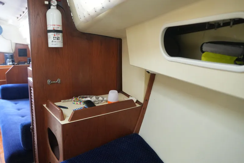 Slide: The Image of Interior of 1985 Pearson 303 sailboat with wooden cabinetry and blue seating. - 17