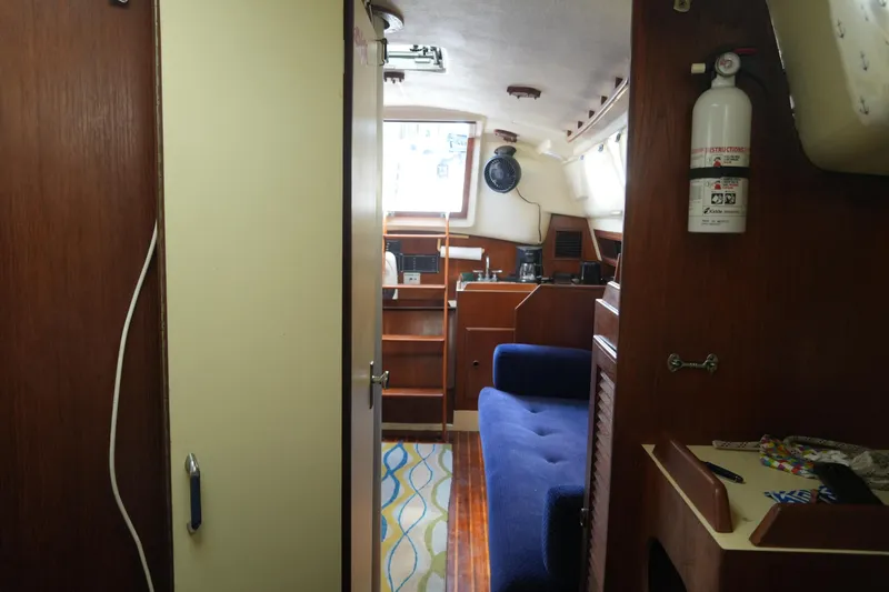 Slide: The Image of Interior of 1985 Pearson 303 sailboat with blue seating and wooden cabinetry. - 18