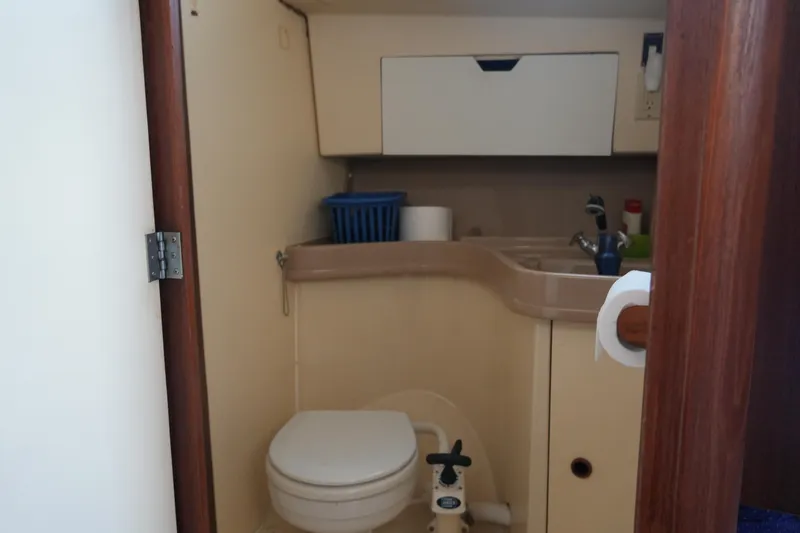 Slide: The Image of 1985 Pearson 303 boat bathroom with toilet, sink, and storage cabinet. - 19