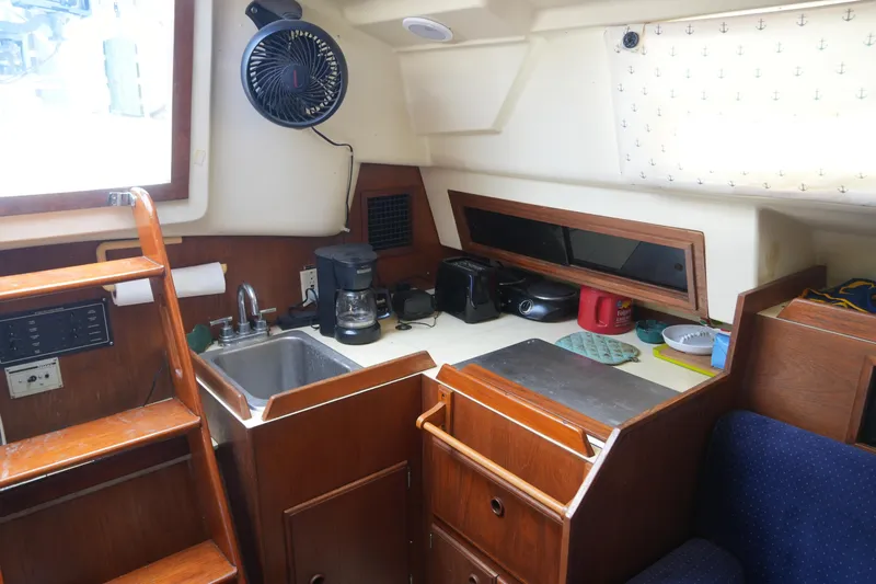 Slide: The Image of 1985 Pearson 303 yacht interior kitchen with sink, coffee maker, and wooden cabinetry. - 24