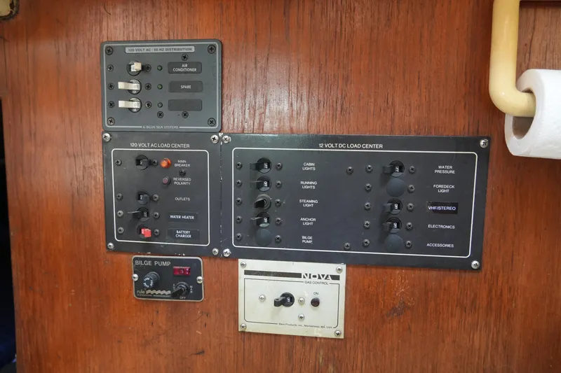 Slide: The Image of Electrical control panel on a 1985 Pearson 303 sailboat, featuring AC and DC load centers. - 27
