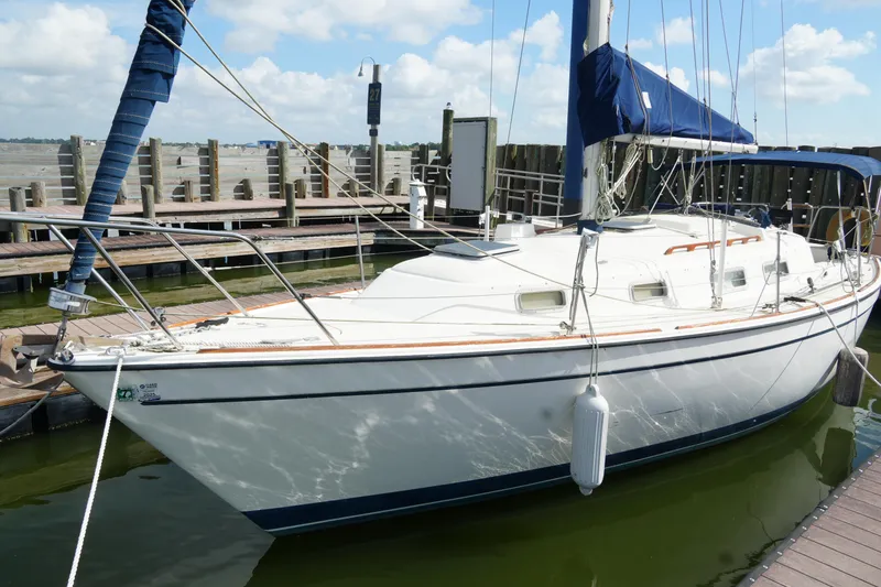 Slide: The Image of 1985 Pearson 303 sailboat docked at marina under blue sky. - 5