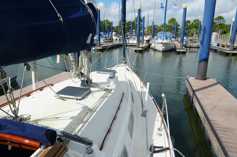 Slide: The Image of Sailboat docked at marina, Pearson 303 model, 1985, with blue sail cover and clear sky. - 7