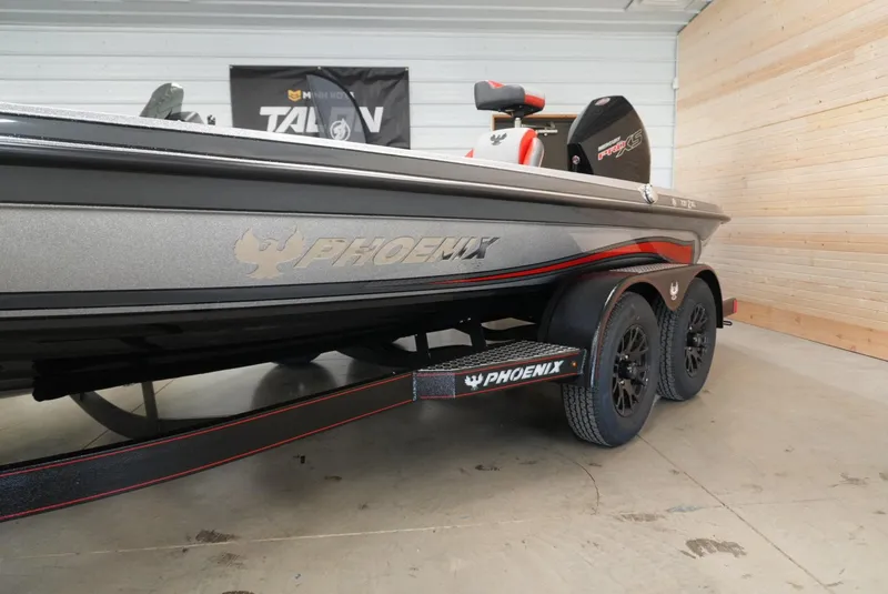 Slide: The Image of 2026 Phoenix 721 ZXL boat on trailer in showroom, showcasing sleek design and branding. - 6