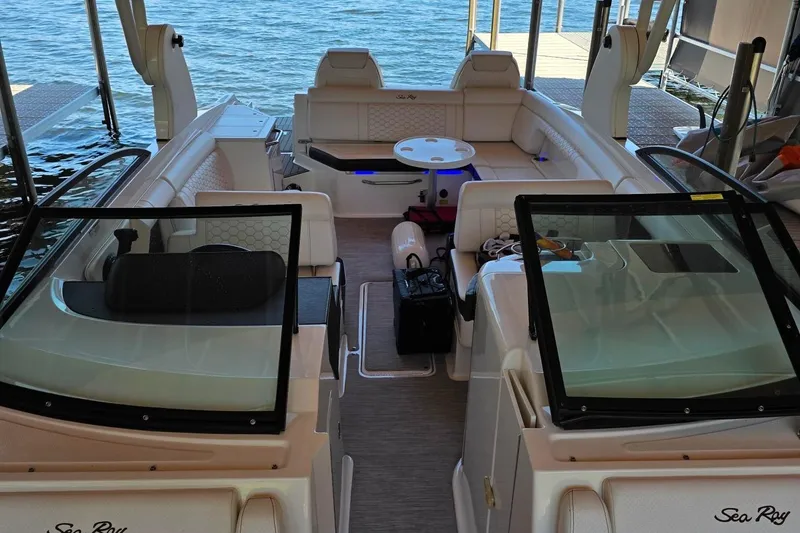 Slide: The Image of 2019 Sea Ray SDX 290 boat interior with seating, table, and water view. - 11