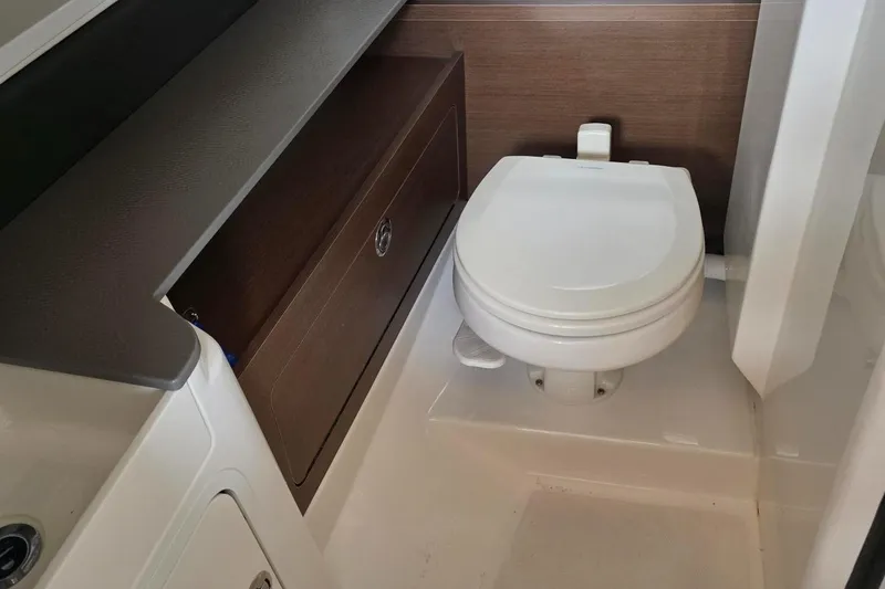 Slide: The Image of 2019 Sea Ray SDX 290 boat bathroom with toilet and storage cabinet. - 13