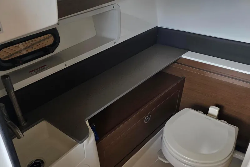 Slide: The Image of 2019 Sea Ray SDX 290 boat bathroom with sink, storage, and toilet. - 14