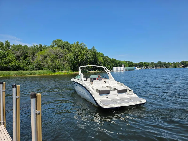 Slide: The Image of 2019 Sea Ray SDX 290 boat on a serene lake with lush green shoreline. - 5