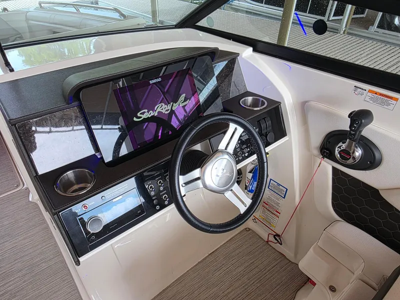 Slide: The Image of 2019 Sea Ray SDX 290 helm with steering wheel, control panel, and touchscreen display. - 8