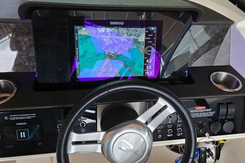 Slide: The Image of Dashboard of 2019 Sea Ray SDX 290 with Simrad navigation display and steering wheel. - 9