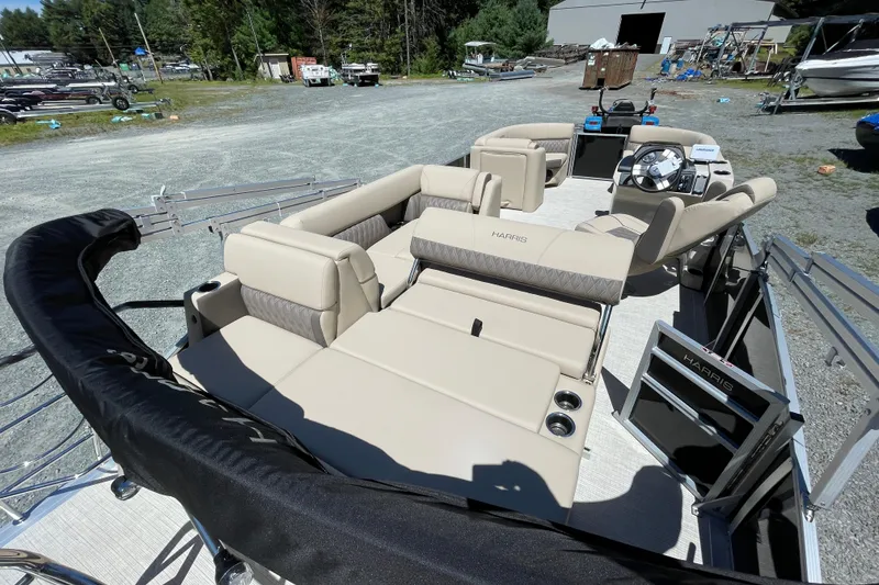 Slide: The Image of 2026 Harris Cruiser 210 pontoon boat with beige seating, parked outdoors. - 11