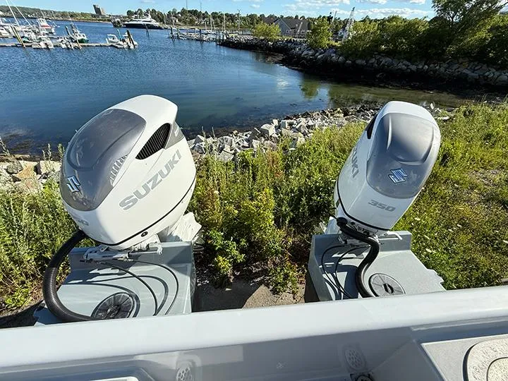 Slide: The Image of Twin Suzuki outboard motors on a Custom T-33 PATROL boat, 2022, near a scenic waterfront. - 6
