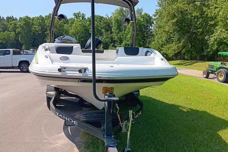 Slide: The Image of 2017 Tahoe 1950 boat on trailer, parked on grass, with trees and vehicles in the background. - 4