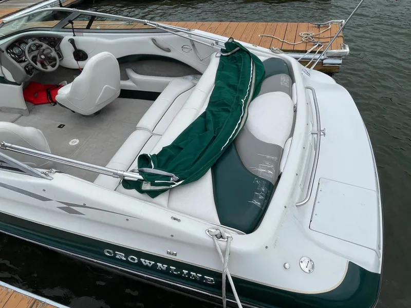 Slide: The Image of 2001 Crownline 202 BR boat with green and white interior, docked by wooden pier. - 3