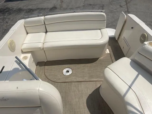 Slide: The Image of 2002 Rinker 250 FV boat interior with white seating and beige carpet. - 10