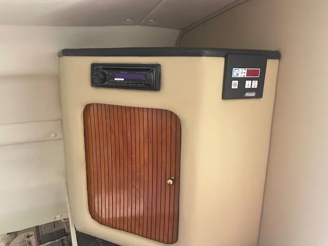 Slide: The Image of 2002 Rinker 250 FV cabin interior with wooden cabinet and control panel. - 7