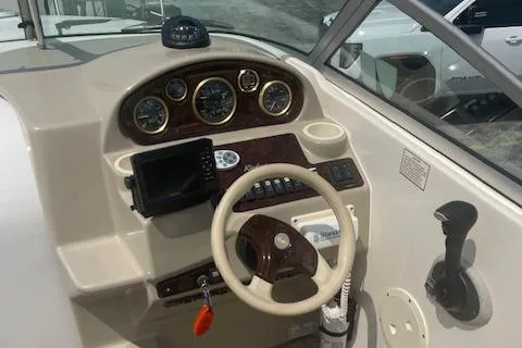 Slide: The Image of 2002 Rinker 250 FV boat dashboard with steering wheel and navigation instruments. - 8