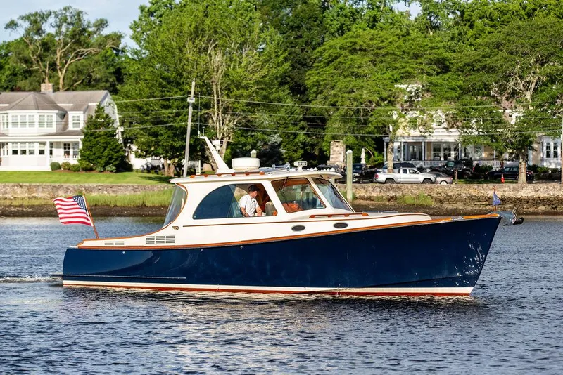 Slide: The Image of 2011 Hinckley Picnic Boat Mark III cruising on a scenic waterway. - 1