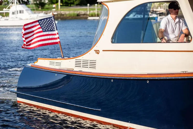 Slide: The Image of 2011 Hinckley Picnic Boat Mark III cruising with American flag on water. - 29