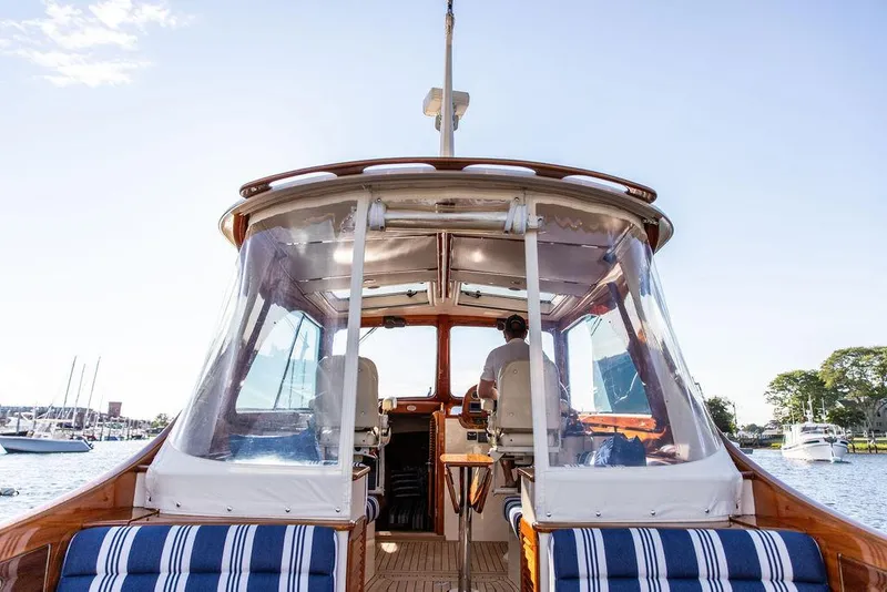 Slide: The Image of 2011 Hinckley Picnic Boat Mark III cruising on a sunny day, featuring striped seating. - 36