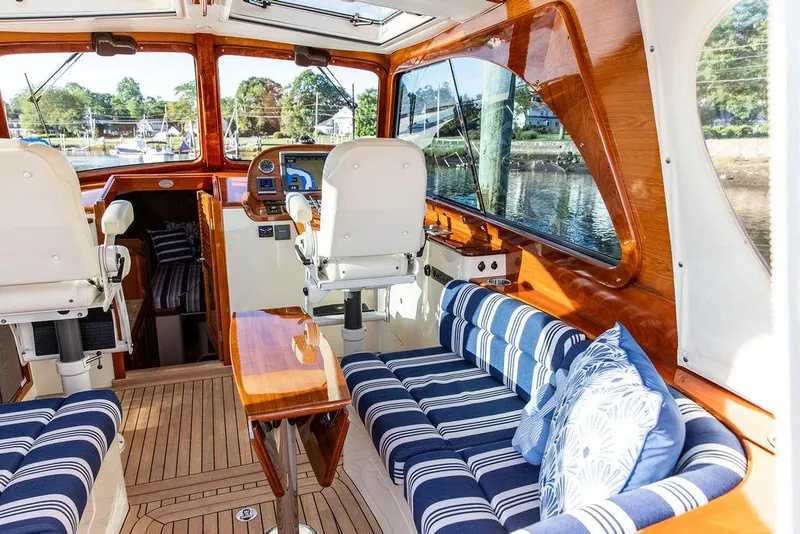 Slide: The Image of Luxurious 2011 Hinckley Picnic Boat Mark III interior with striped seating and polished wood finishes. - 44