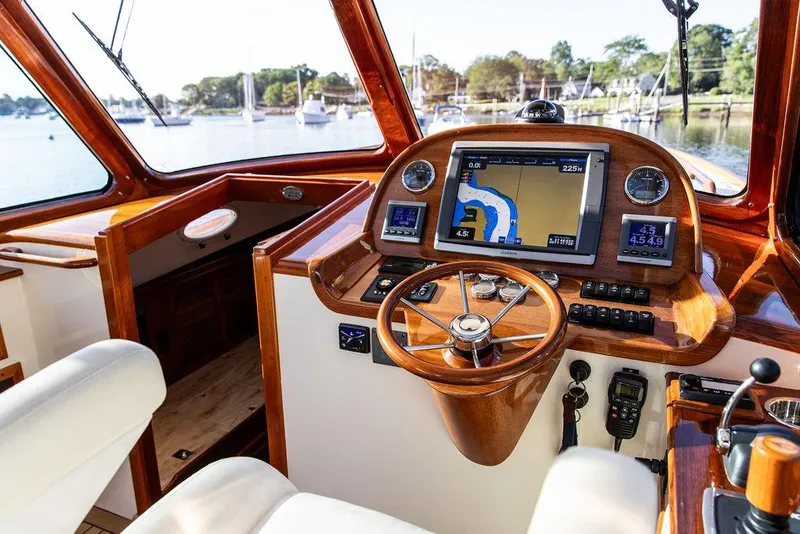Slide: The Image of Hinckley Picnic Boat Mark III 2011 helm with navigation system and wooden steering wheel. - 46